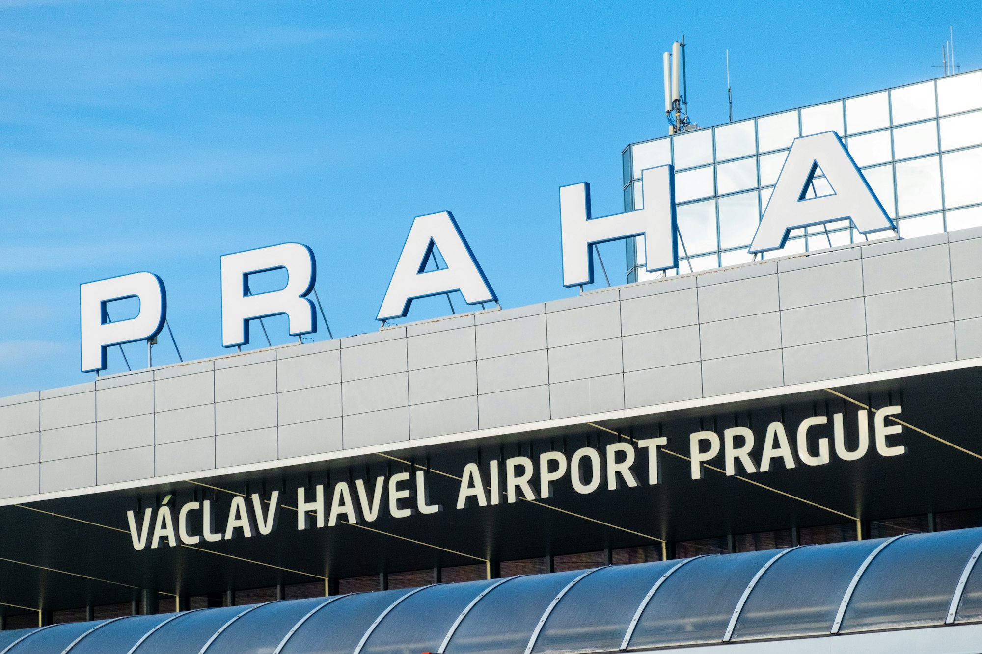 Facade of Vaclav Havel airport building under clear blue sky