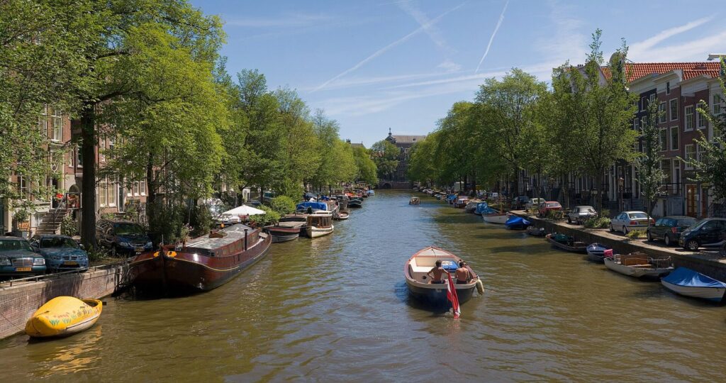 Amsterdamský kanál lemovaný úzkými domy v létě